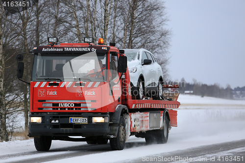 Image of Red Tow Truck Tows a Breakdown Car in Winter