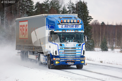 Image of Scania 164L Semi Truck Transports Goods on Snowy Road