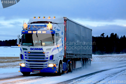 Image of Super Scania Semi on Snowy Road at Sunset