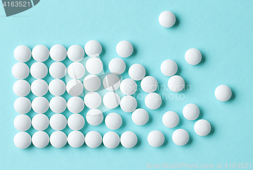 Image of white pills on blue background