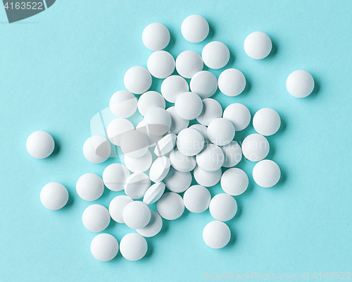 Image of white pills on blue background