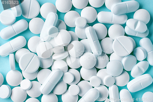 Image of various white pills on blue background