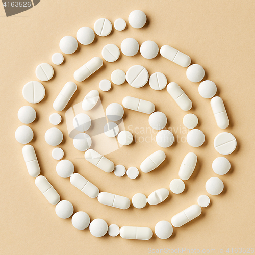 Image of white medicine pills on beige background