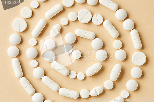 Image of white medicine pills on beige background