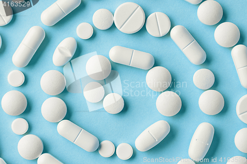 Image of white medicine pills on blue background