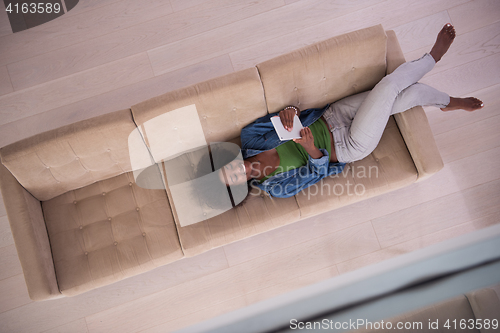 Image of african american woman at home with digital tablet top view