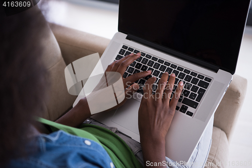 Image of African American women at home in the chair using a laptop