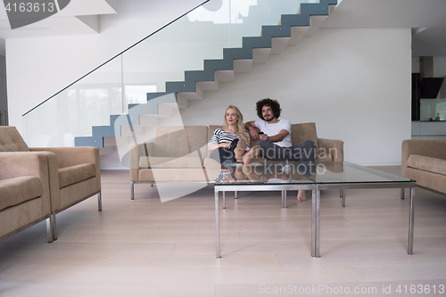 Image of Young couple on the sofa watching television