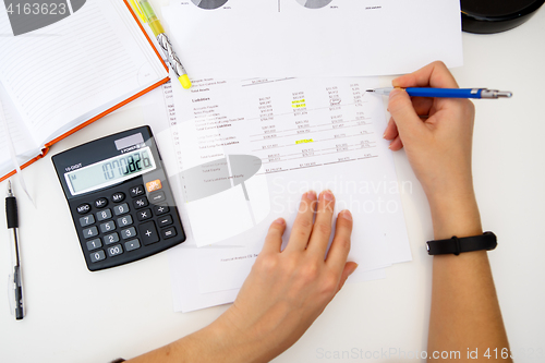 Image of Woman prepares accounts at table