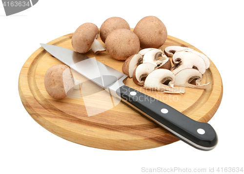 Image of Knife with sliced and whole chestnut mushrooms on chopping board