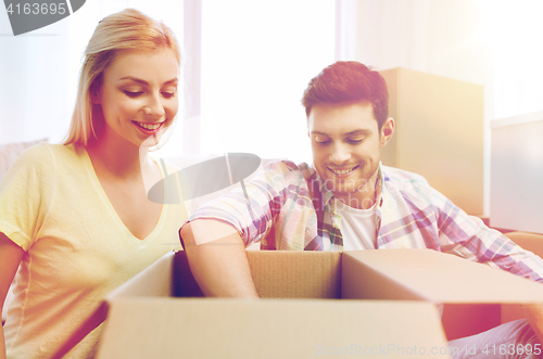 Image of smiling couple with big boxes moving to new home