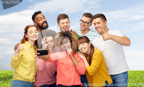 Image of group of people taking selfie by smartphone