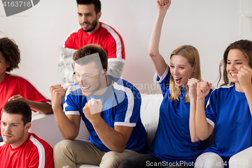 Image of friends or football fans watching soccer at home