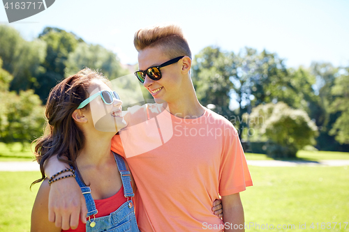 Image of happy teenage couple looking at each other in park