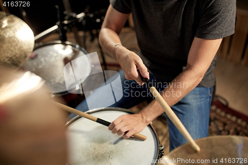 Image of male musician playing drums and cymbals at concert