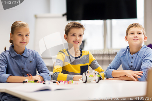 Image of happy children building robots at robotics school