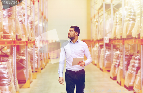 Image of businessman with tablet pc at warehouse