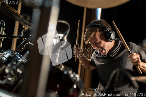 Image of male musician playing drums and cymbals at concert