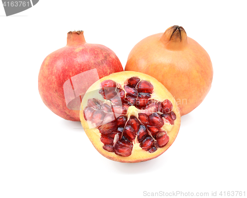 Image of Two pomegranates and a cut half showing seeds