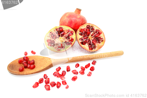 Image of Pomegranate and two cut halves with seeds removed with spoon