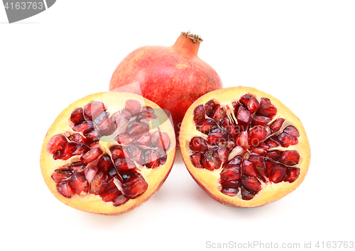 Image of Whole red pomegranate and two cut halves showing seeds