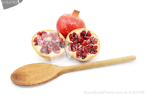 Image of Pomegranate with two cut halves, with spoon for removing seeds