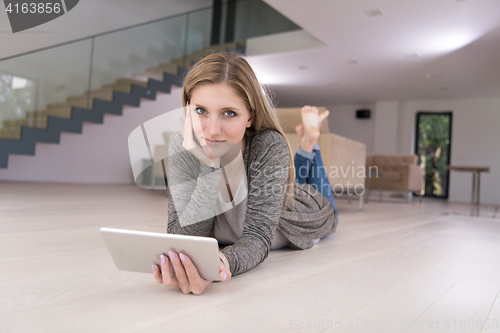 Image of young women used tablet computer on the floor