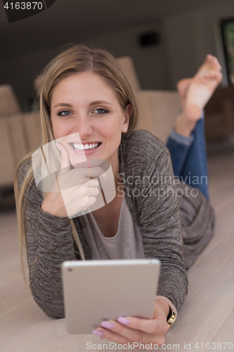 Image of young women used tablet computer on the floor