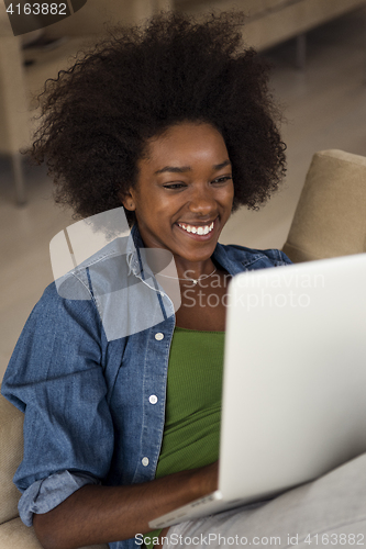 Image of African American women at home in the chair using a laptop