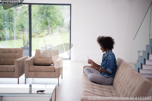 Image of african american woman at home with digital tablet