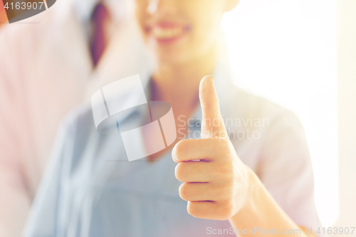 Image of close up of doctor or nurse showing thumbs 