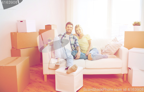 Image of happy couple with big cardboard boxes at new home