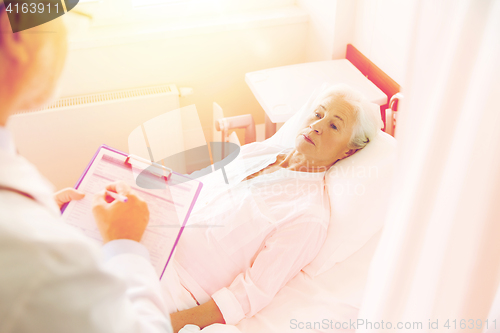 Image of senior woman and doctor with clipboard at hospital