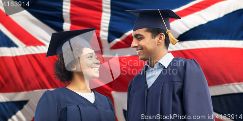 Image of happy students or bachelors in mortar boards