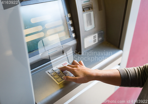 Image of close up of hand entering pin code at atm machine