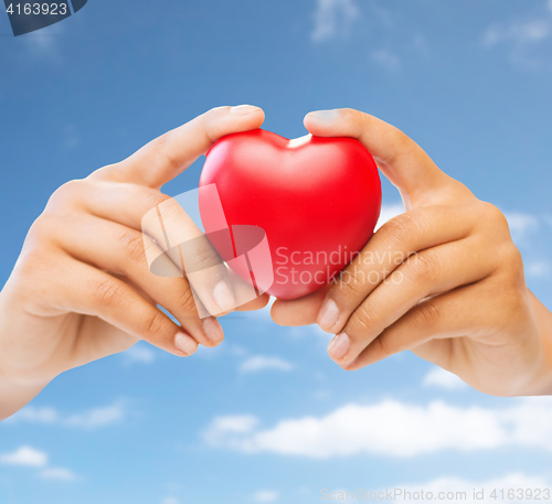 Image of close up of woman hands with red heart