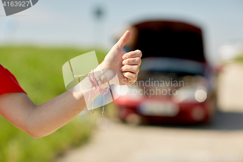 Image of woman with broken car hitching at countryside