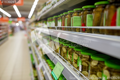 Image of jars of pickles on grocery or supermarket shelves