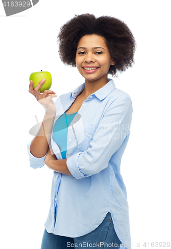 Image of happy african american woman with green apple