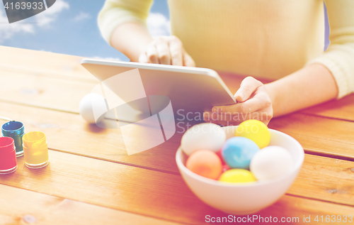 Image of close up of woman with tablet pc and easter eggs