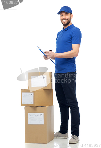 Image of happy delivery man with parcel boxes and clipboard