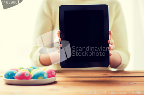 Image of close up of woman with tablet pc and easter eggs