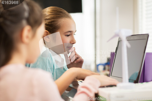 Image of children with laptop and wind turbine at school