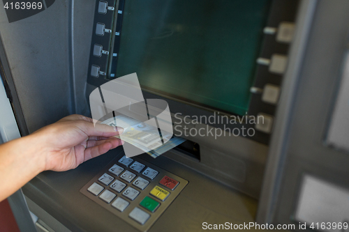 Image of close up of hand withdrawing money at atm machine