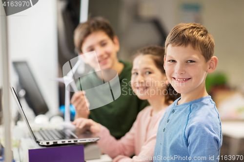 Image of children with laptop and wind turbine at school