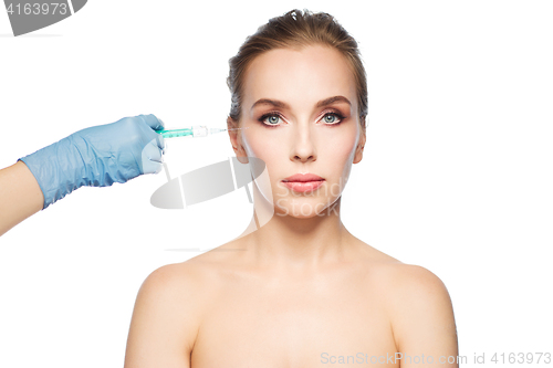 Image of woman face and hand with syringe making injection