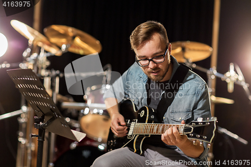 Image of man playing guitar at studio rehearsal