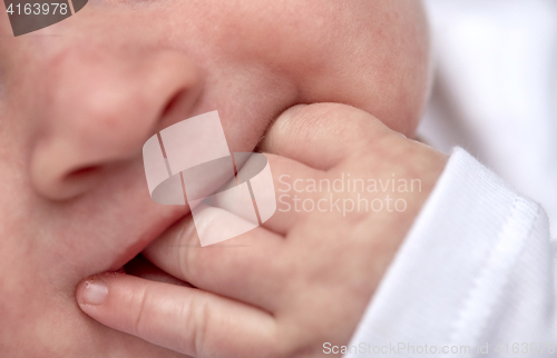 Image of close up of baby sucking his fingers