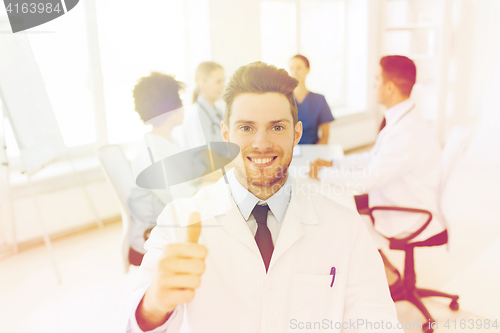 Image of happy doctor over group of medics at hospital