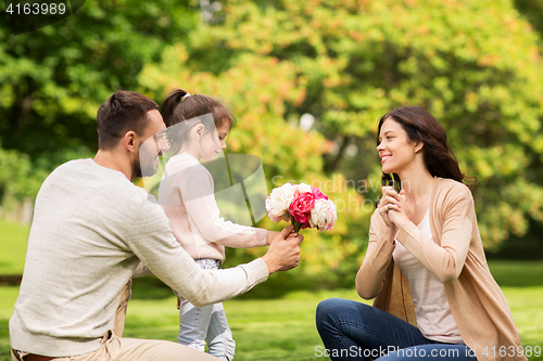 Image of happy family with flowers in summer park
